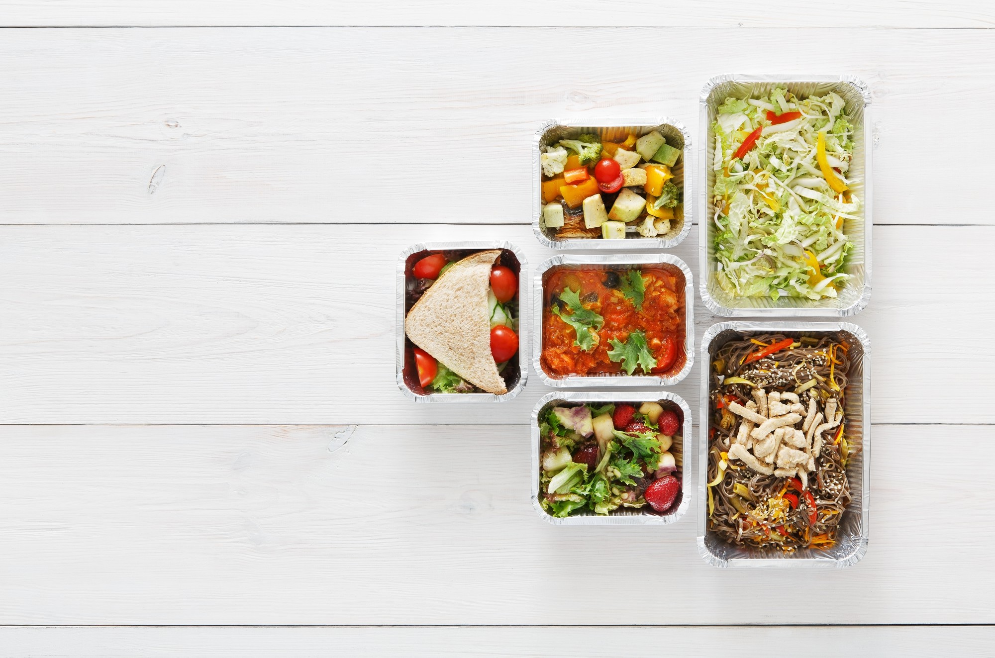 Prepared meal in minimal container on wooden table